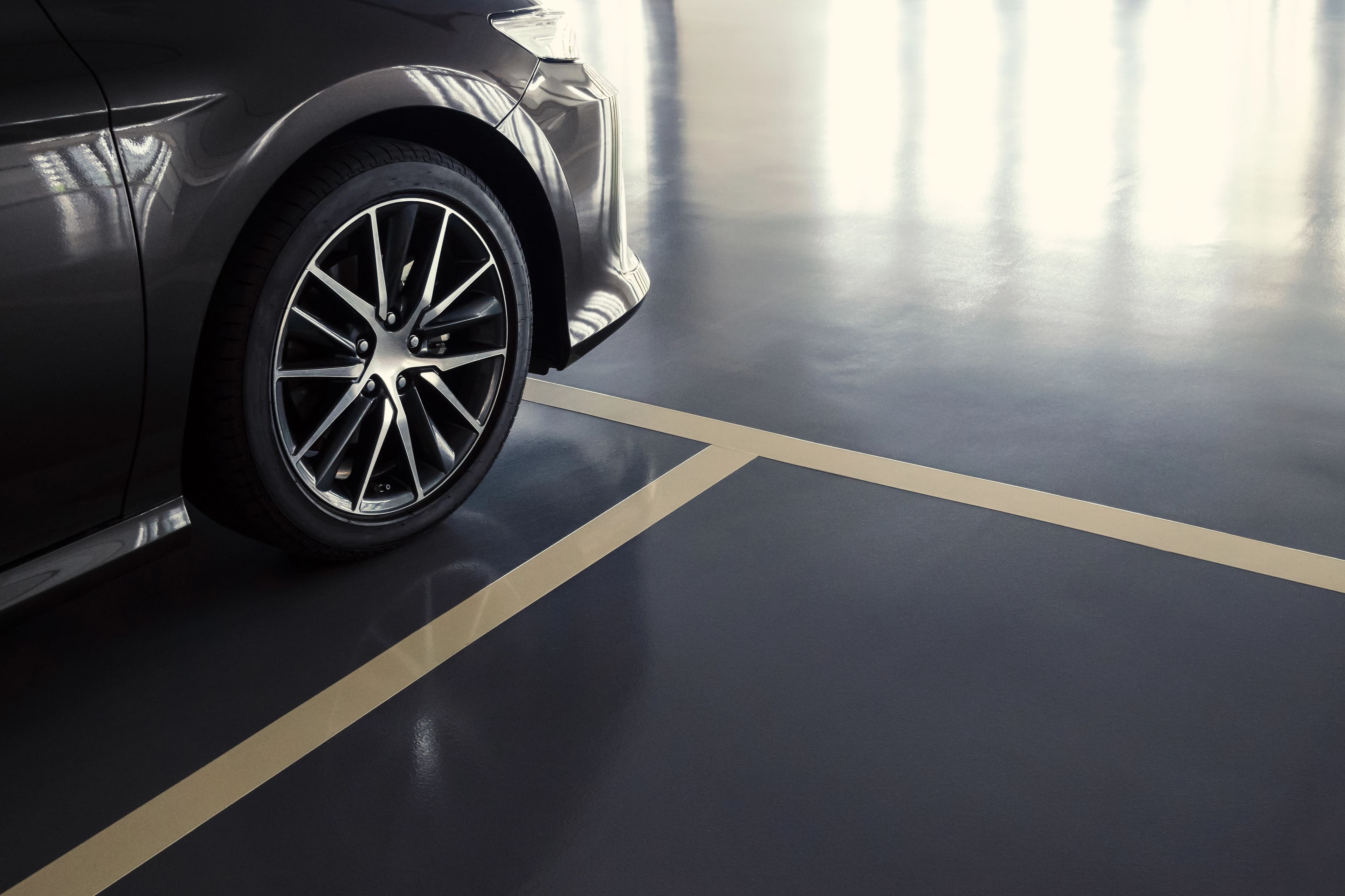 Car parked on a dark epoxy garage floor by Colin Coatings, serving Urbandale, Iowa
