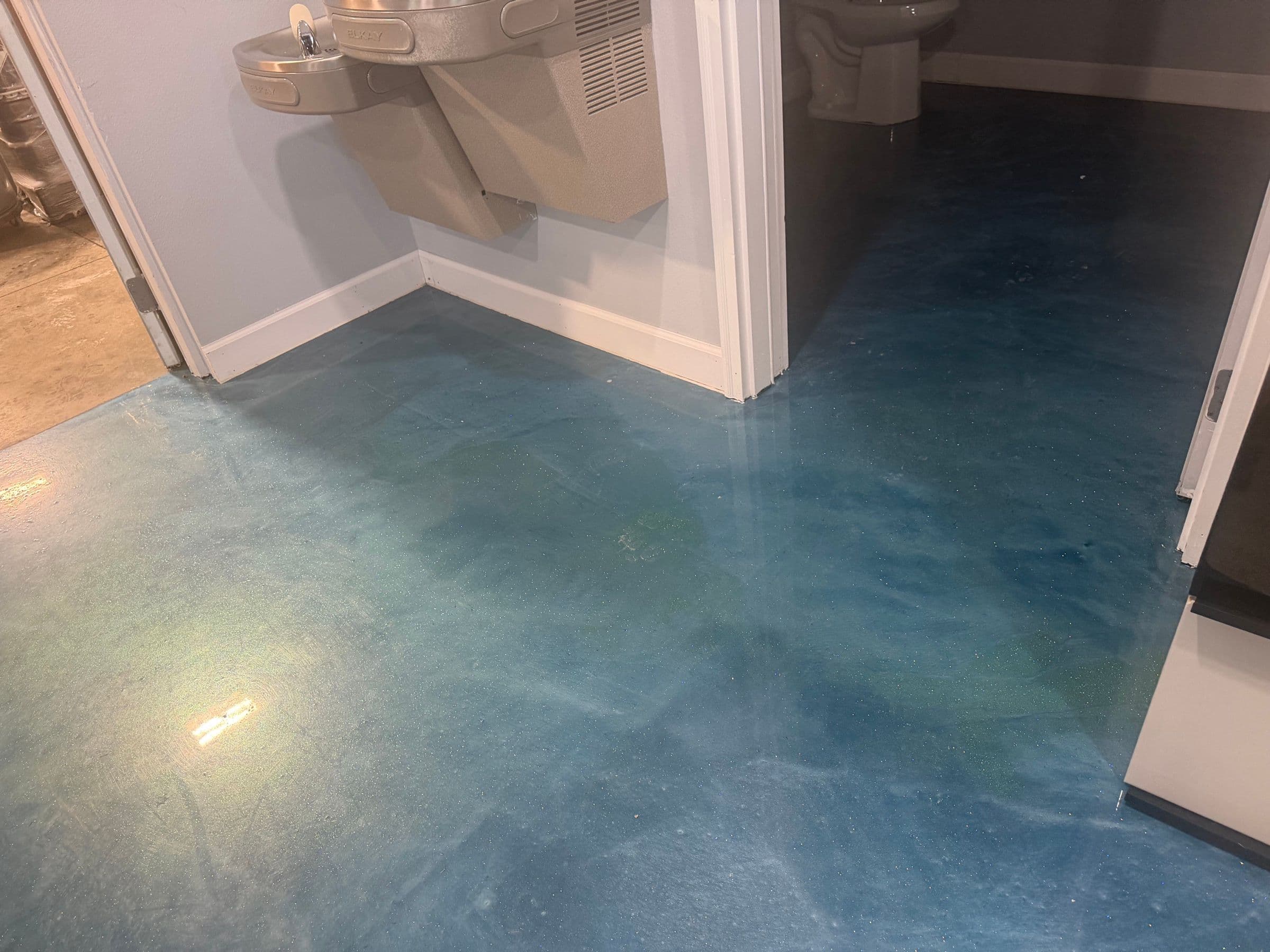 Blue metallic epoxy floor in a finished room by Colin Coatings, Des Moines, Iowa