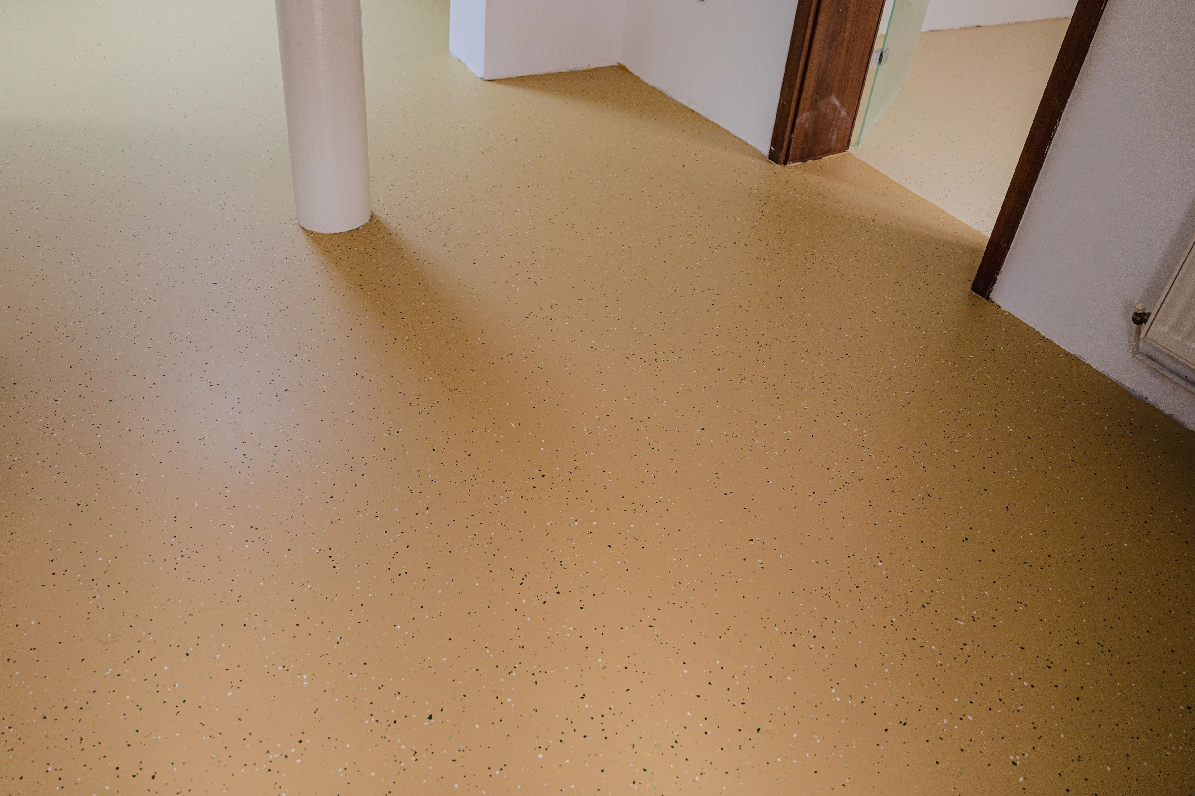 Tan solid-color epoxy floor in a finished room by Colin Coatings, serving Urbandale, Iowa